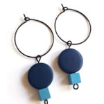 colorful dark blue and blue wooden beads hanging on a black creole by Pop-a-porter