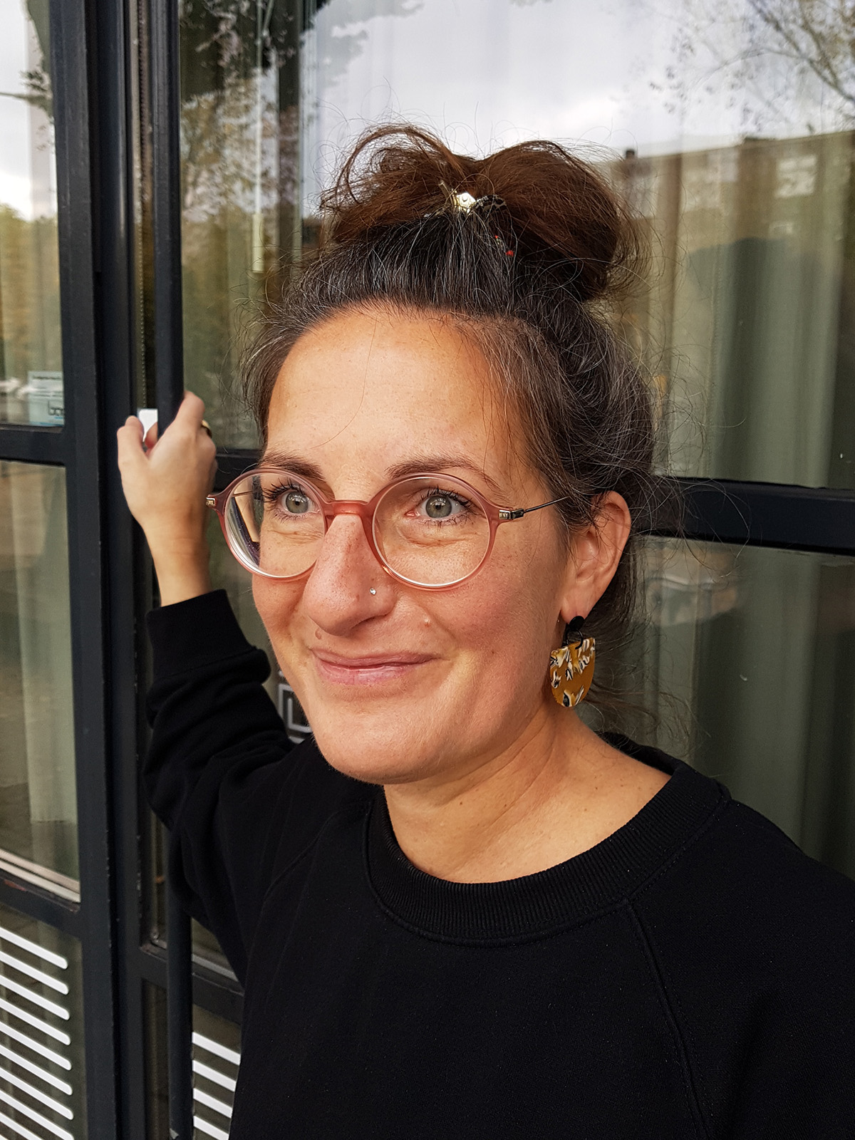 acetate_earrings_ocher_model_pin Ocher pattern acetate pendant earrings set on matt-silver ear studs.